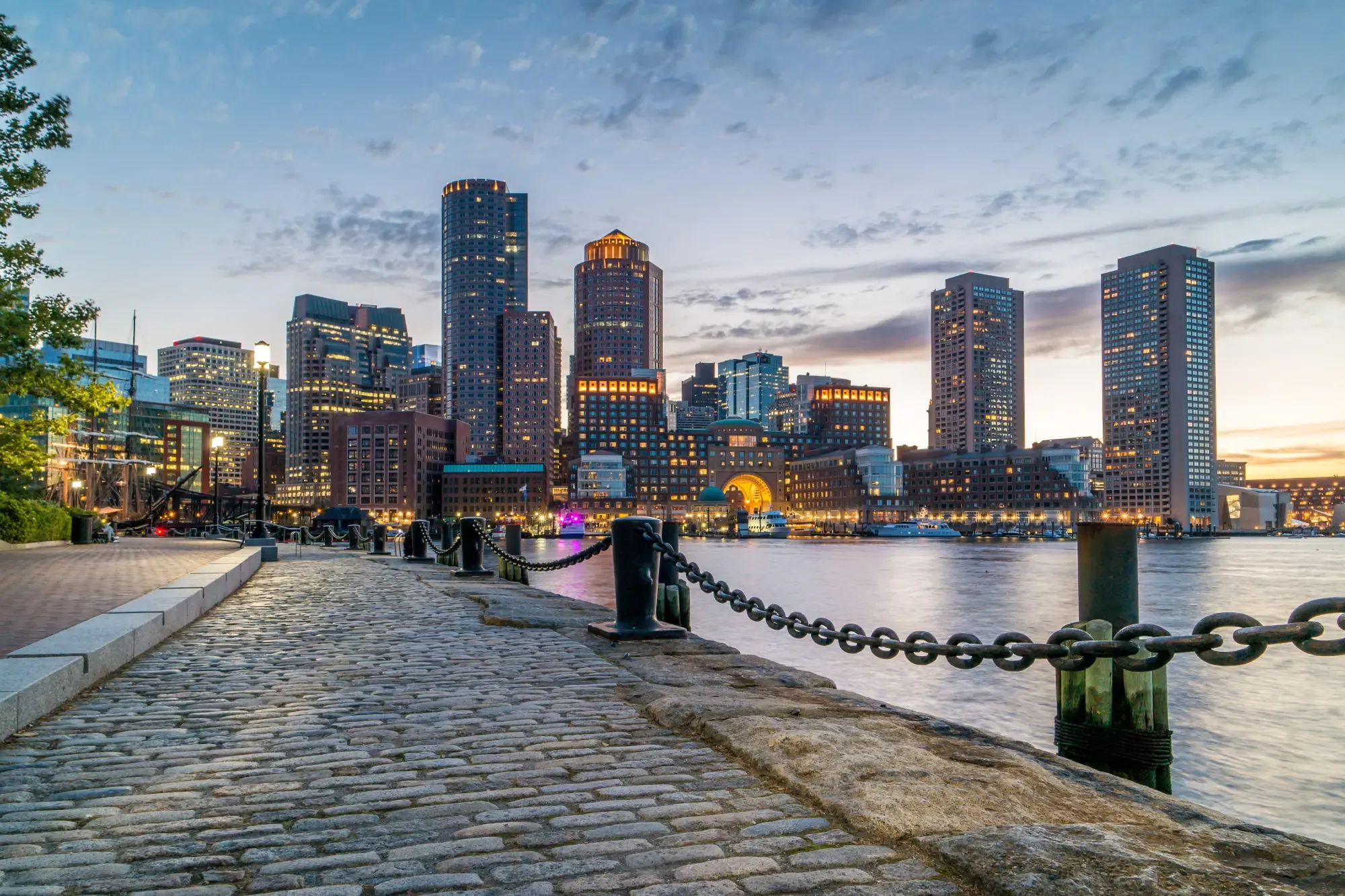 City skyline at dusk, featuring illuminated buildings against a colorful twilight sky